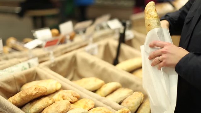 female hand takes fresh bread in the package
