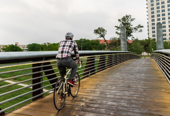 Fototapeta na wymiar Man Biking To Work to Downtown Houston Over City Bridge