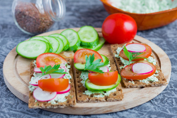 Fototapeta na wymiar delicious diet sandwiches with cottage cheese with herbs and vegetables on a gray background