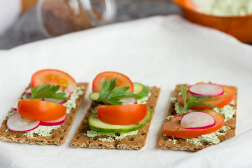 delicious diet sandwiches with cottage cheese with herbs and vegetables on a white background