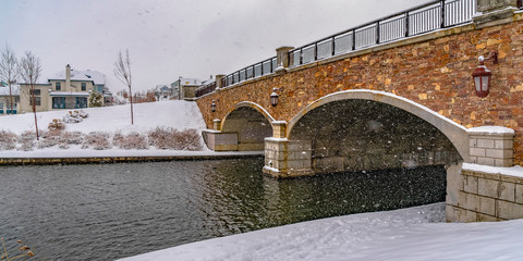 Bridge over the rippling water of Oquirrh Lake with snowy white shore