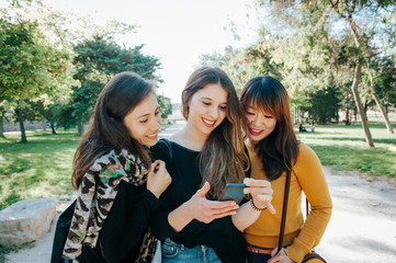 group of three friends talking and walking on the street. 