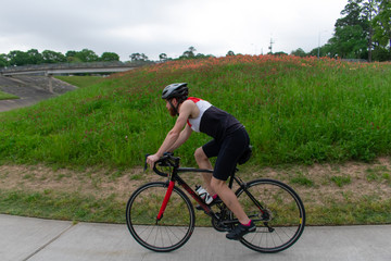 Fototapeta premium Bicyclist In Spring Biking Through a Field of Flowers blurred motion