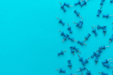 blue pushpins on the blue backgound. top view of lots of push pins