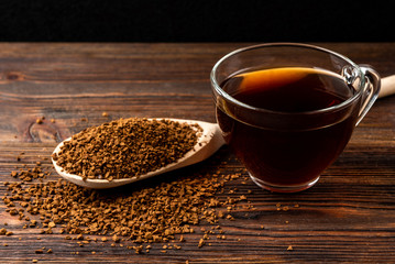 Granulated coffee on dark wooden background.