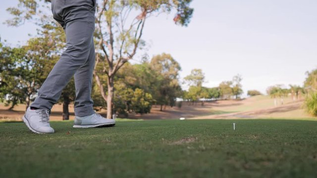 Golfer hitting the ball with a driver down the course