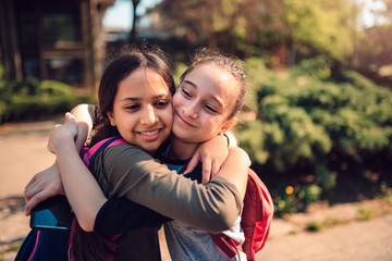 Schoolgirls hugging on a first day of school