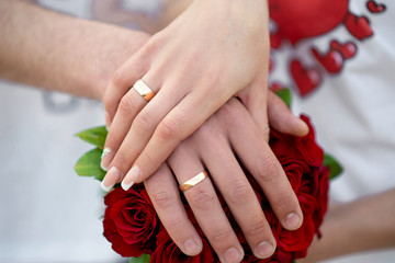 Obraz na płótnie Canvas hands with rings on the bouquet