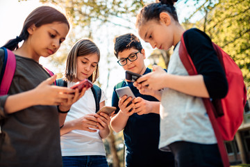 Group of school kids hang out and using smart phone
