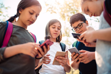 Group of school kids hang out and using smart phone