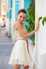 Portrait close up of young beautiful brunette woman in a beige dress