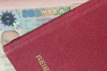 Visa stamp in passport, passport in the background. Travel concept. Close up.