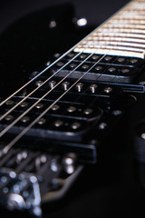 Detail of electric guitar. Close-up. Soft selective focus. On black background