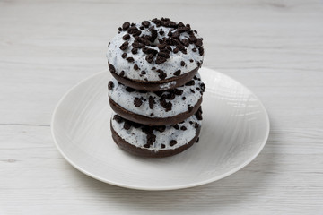 Donuts in a plate on white wood background, close-up