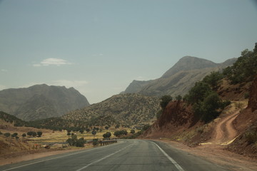 asfaltowa prosta długa droga biegnąca w kierunku górskiego krajobrazu w iranie - obrazy, fototapety, plakaty