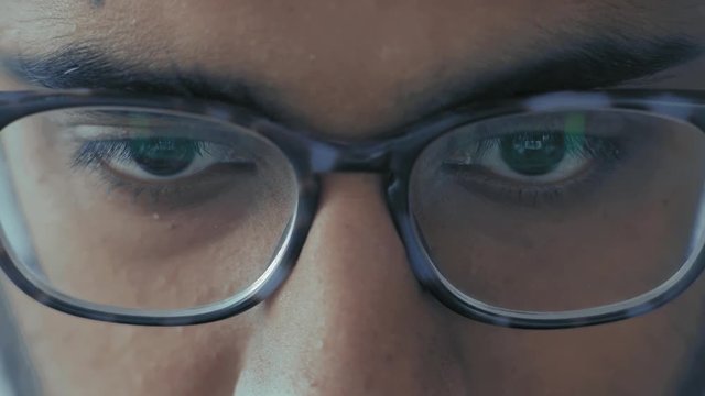 Close-Up, Indian Student in Glasses Pensively Looks into Laptop Monitor