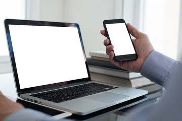 Mockup image of businessman using smartphone working on laptop