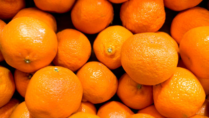 Macro image of lots of beautiful oranges. Closeup texture or pattern of fresh ripe fruits. Beautiful food background
