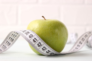 apple and measuring tape on a colored background side view.