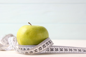 apple and measuring tape on a colored background side view.