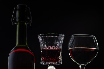 Rose wine. Red wine in bottle with two wine glasses over dark background