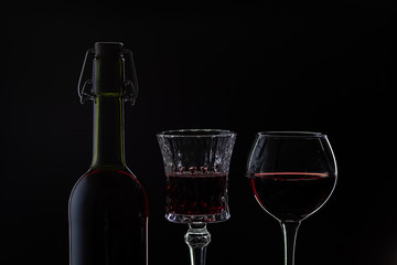 Rose wine. Red wine in bottle with two wine glasses over dark background