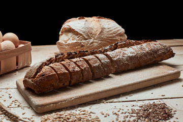Freshly baked bread .Top view of sliced wholegrain bread on dark ructic wooden  background closeup. Bread at leaven. Unleavened bread.