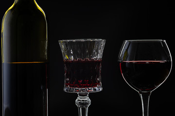 Rose wine. Red wine in bottle with two wine glasses over dark background