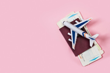 Preparación concepto de viaje, avión, pasaporte y tickets aéreos sobre un fondo liso y aislado de color rosa. Vista superior y de cerca. Copy space 