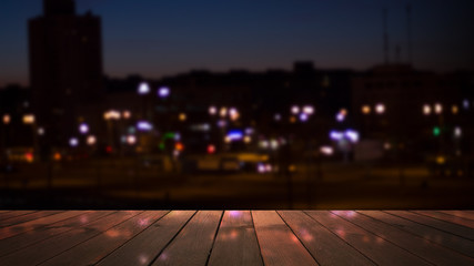 Empty wooden table with blurred cityscape, blurred city lights reflected on wooden background....