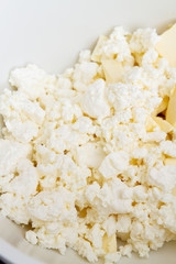In a mixing bowl are the ingredients butter and cottage cheese for making cookies