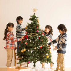 クリスマスツリーの飾り付けをする子供達