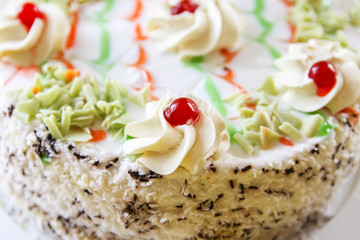 Traditional sweet birthday cake with colorful candles.