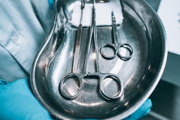 Several surgical instruments lie on a tray