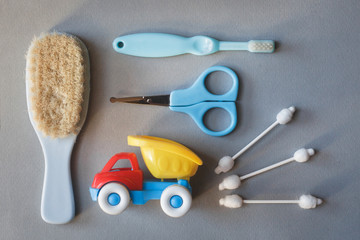 Fototapeta premium Baby on white background with clothing, toiletries, toys and health care accessories. Wish list or shopping overview for pregnancy and baby shower. View from above. Child feeding changing and bathing