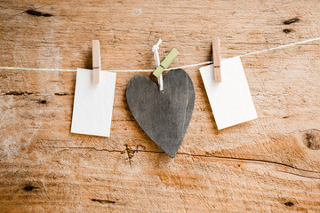 Liebevolle Nachricht - Zettel und Herz an Leine mit Wäscheklammern mit Holz im Hintergrund