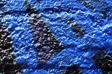 Close up texture of colorful graffiti paint on old cracked concrete walls in high resolution