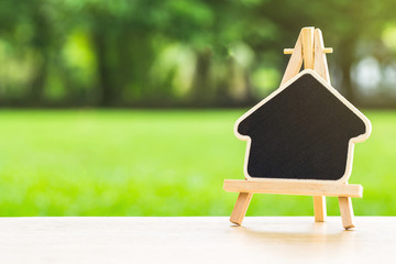 blank blackboard for fill text,on wooden table over blurred green garden background. back to school concept,
