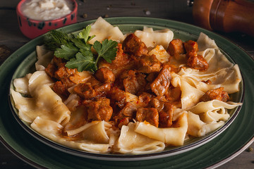 Azerbaijani cuisine. Khingal with slices of meat and herbs on the plate. Closeup