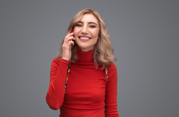 Smiling lady in sweater speaking on phone