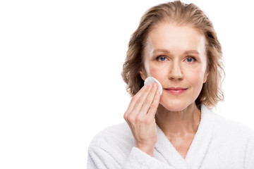 Fototapeta premium mature woman wiping face with cotton pad Isolated On White with copy space