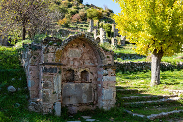 Naklejka premium Part of the byzantine archaeological site of Mystras in Peloponnese, Greece. View of an old stone fountain and remains of buildings in the lower city of the ancient Mystras