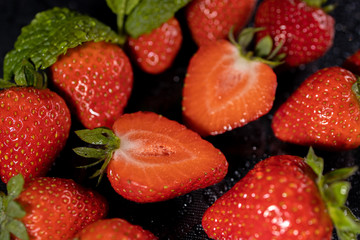 fresh red strawberries macro on black table waterdrops