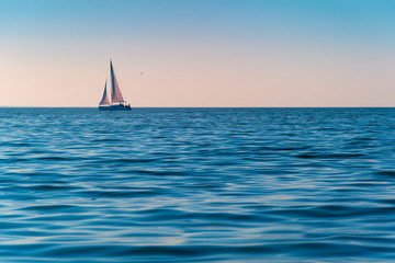 Sailboat in the sea in the evening sunlight over sky background. Luxury summer adventure or active...