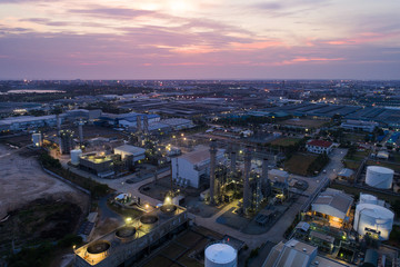 Fototapeta premium Aerial view night light oil terminal is industrial facility for storage of oil and petrochemical. oil manufacturing products ready for transport and business transportation. power electric plant.