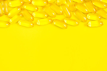 Omega 3 fish oil capsules on yellow background. Concept of healthcare. Top view, flat lay, copy space.