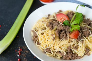 pasta with ground beef and tomato on a white plate