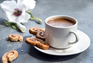 Cup of coffee with cookies, Magnolia flower in the background