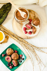 Homemade chocolate vanilla and fresh berries on wooden plate, white linen tablecloth backgound. A cup of herbal tea. Top view.