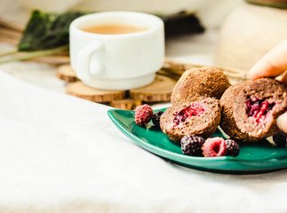 Truffles Chocolate figs, fresh berries and avocados. Homemade healthy vegan candy ball in the hands of a young woman. Close-up.